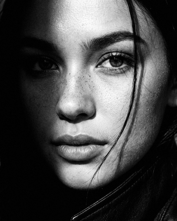 Nova Rai, a close portrait, half her face in shadow, black and white